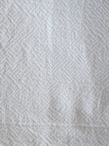 detail of subtle structure on white linen placemat