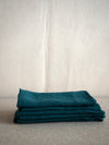 pile of dark green linen napkins with a waffle structure by Linge Particulier