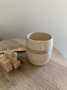 handmade ceramic coffee cup with small wooden spoon and sugar