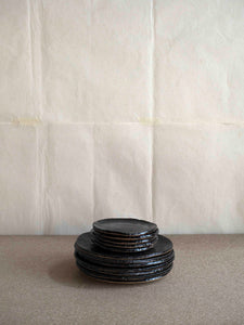 pile of black tableware plates handmade by the French ceramicist Jérôme Hirson