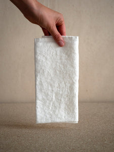 hand holding a white linen napkin with a beautiful texture
