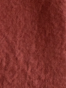 detail of texture on French woven linen in dark red colour