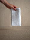 woman holding a white linen napkin with waffle texture from Linge Particulier