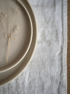 handmade cream plates with white linen tablecloth