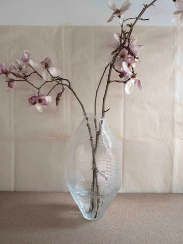 mouth blown transparent vase by Vanessa Mitrani with magnolia blossoms